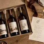 Coffret cadeau 3 bouteilles de vin rouge blanc bulles sur table en chêne clair