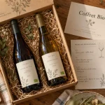 Coffret cadeau vin bio sur table en bois, bouteilles et tire-bouchon